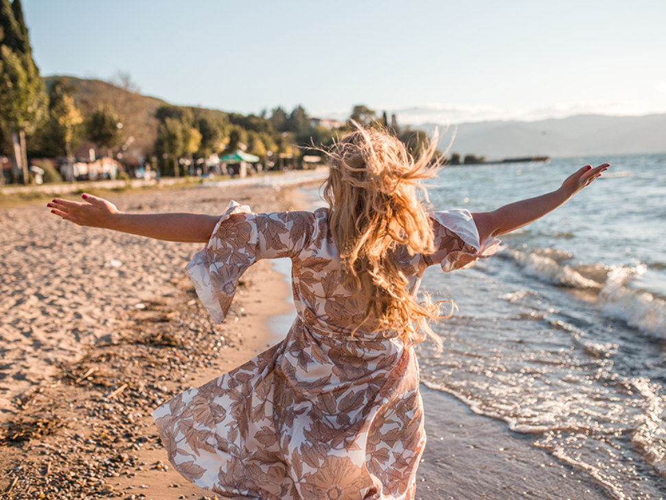 Confident blonde plus size woman standing on the beach